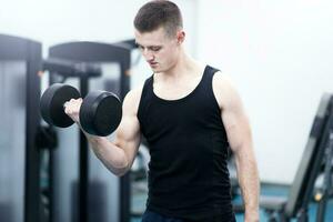 atletisk man med en hantlar i Gym foto