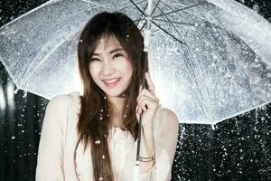Lycklig flicka innehav transparent paraply bland de regn foto