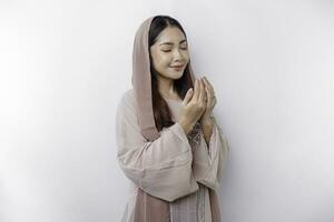 religiös skön asiatisk muslim flicka bär en slöja bön- till Gud, isolerat förbi vit bakgrund foto