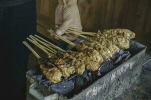 sate buntel eller satay buntel är satay tillverkad från mald fårkött insvept i fårkött fett är varelse grillad på träkol foto