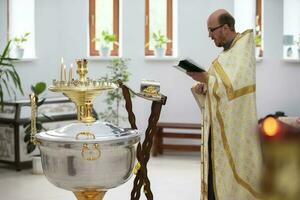 juli 15, 2020 belarus, stad av gomel. stad kyrka. de präst läser en bön innan de dop av de barn. foto