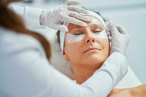kvinna har kosmetologi ögonbryn behandling i skönhet salong foto