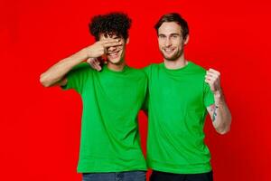 rolig vänner grön t-tröjor kramar känslor glädje röd bakgrund foto