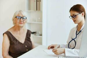 sjuksköterska i vit täcka konversation med de patient hälsa vård foto