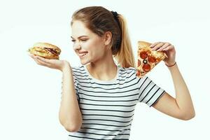 kvinna i randig t-shirt äter pizza snabb mat diet ljus bakgrund foto