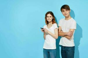 glad ung par i vit t-tröjor telefoner i händer kommunikation livsstil foto
