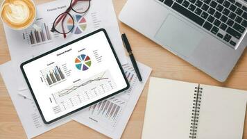 läsplatta med diagram och rapporter på kontor skrivbord arbetsplats. topp se platt lägga foto