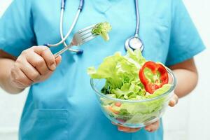 asiatisk dietist innehav friska mat för patient i sjukhus, näring och vitamin. foto