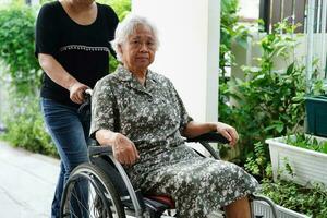 vårdgivare hjälp asiatisk äldre kvinna handikapp patient Sammanträde på rullstol i sjukhus, medicinsk begrepp. foto