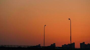de skön solnedgång se med de byggnader' silhuett och orange Färg himmel som bakgrund i de stad foto