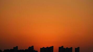 de skön solnedgång se med de byggnader' silhuett och orange Färg himmel som bakgrund i de stad foto