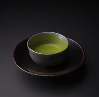 matcha te i de kopp isolerat på svart bakgrund stänga upp. japansk te ceremoni begrepp. ai genererad. foto