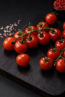 utsökt färsk körsbär tomater på en kvist med kryddor och örter foto