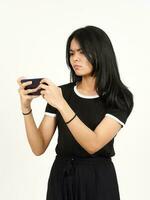 spelar mobil spel på smartphone av skön asiatisk kvinna isolerat på vit bakgrund foto