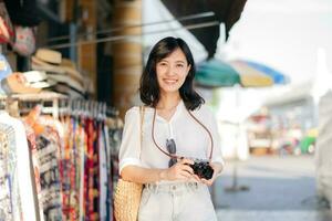 porträtt ung skön kvinna med kamera utforska gata i Bangkok, thailand foto