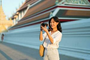 porträtt av asiatisk kvinna resande använder sig av kamera på gata av Bangkok, thailand. Asien sommar turism semester begrepp foto