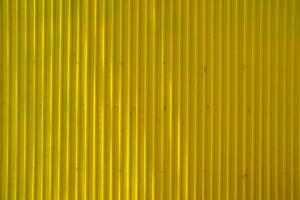 ljus stråle på gul måla gammal zink vägg bakgrund. foto