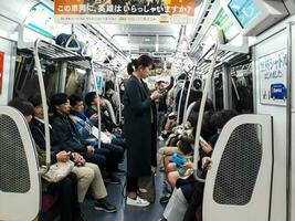 Osaka, japan på april 9, 2019. Foto av de situation inuti en tåg i osaka som är fullt med folk med passagerare på de sätt Hem från arbete.