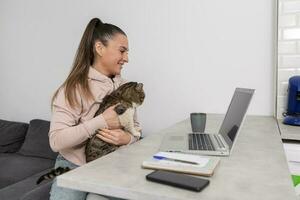 glad kvinna med katt har video chatt med veterinär foto