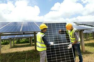 ett team av manliga ingenjörer är på väg att installera solpaneler. vid solkraftverket beställde ingenjörsteamet och installerade solceller. foto