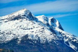 snö täckt berg förbi de fjord i Norge. scandinavian landskap i de norr av Europa foto