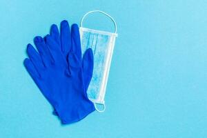 topp se av disponibel medicinsk mask och nitril handskar på blå bakgrund. personlig skydd begrepp med kopia Plats foto