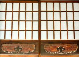 närbild japansk gammal trä- dörrar med dekorativ mönster. foto