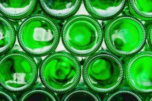 glas flaskor grön. grön glas flaskor av öl. vägg bildas förbi grön flaskor. grön flaskor bakgrund. tömma glas flaska med belysning foto