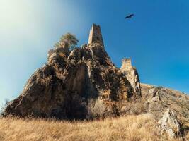 solig eftermiddag i de kaukasus berg. medeltida torn komplex vovnushki, ett av de äkta medeltida slottsliknande torn byar, belägen på de extremitet av de berg räckvidd i ingushetia foto