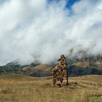 ett gammal sten idol på de bakgrund av dimmig berg. gravstenar tillverkad av sten. stur-digora område. norr ossetia. foto