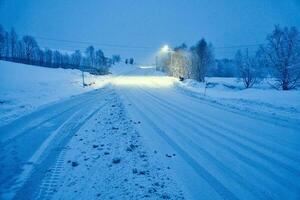 vinter- landskap i skandinavien. snöig väg med snö täckt träd. landskap foto