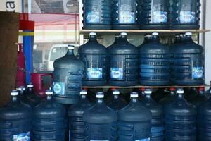 semarang, Indonesien-maj 05, 2023-högar av liter av aqua mineral vatten i främre av de mataffär. foto