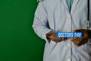 läkare stående på grön bakgrund. håll de doktorer dag papper text. medicinsk och sjukvård begrepp. foto