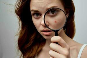 Söt kvinna med en finne på de ansikte kosmetologi studio foto