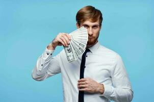 man i vit skjorta med slips innehav pengar i hans händer rikedom företag foto