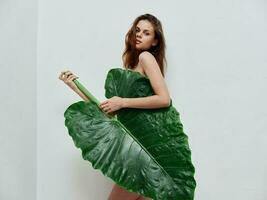 kvinna med grön handflatan blad glamour naken kropp foto