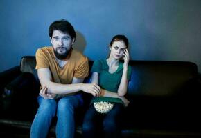 stilig man och ung kvinna på soffa inomhus tittar på TV i de kväll foto