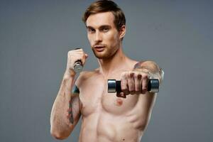 sportig manlig kroppsbyggare med pumpade upp ärm muskler och Färg tatuering hantel biceps foto