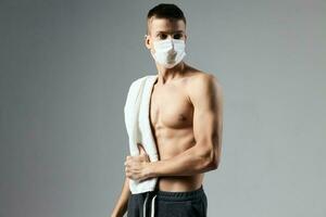 sport kille med handduk på axlar medicinsk mask Framställ träna foto