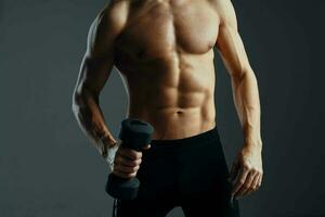 en man med en pumpade upp Tryck träna med hantlar övningar mörk bakgrund foto