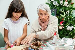 mormor undervisning henne barnbarn på vilket sätt till göra jul nativity hantverk - verklig familj foto