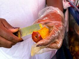 stänga upp av en kvinna peeling en chontaduro på cali stad Centrum foto
