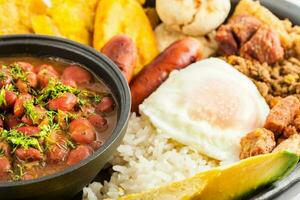 traditionell colombianska maträtt kallad banda paisa en tallrik typisk av medellin den där inkluderar kött, bönor, ägg och groblad foto