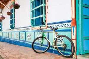 bycicle Nästa till en skön blå och vit hus på guatape, colombia foto