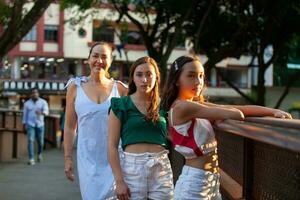 turister på ett av de broar längs de cali flod boulevard i de stad av cali i colombia. mor och tonåring döttrar reser begrepp. Lycklig familj begrepp. foto