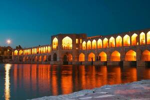 isfahan, iran - 15:e juni, 2022, turist muslim besök gammal khajoo bro på natt, tvärs över de zayandeh flod i isfahan, iran. foto