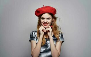 glad kvinna randig t-shirt med röd hatt leende charm modell foto