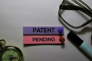 patent i väntan på text på klibbig anteckningar isolerat på kontor skrivbord foto