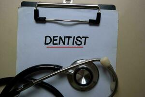 tandläkare skriva på en pappersarbete och stetoskop isolerat på kontor skrivbord. medicinsk eller sjukvård begrepp foto