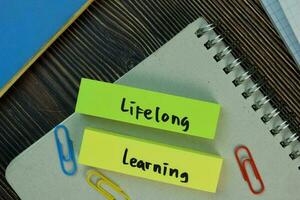 livslångt inlärning skriva på klibbig anteckningar isolerat på trä- tabell. utbildning begrepp foto